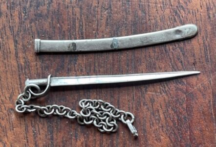 A vey small miniature sword and scabbard